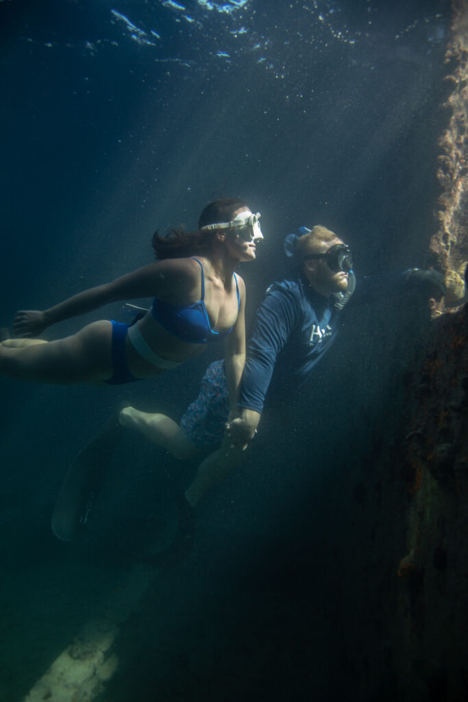 Cole and Emily peering through a port hole of the Sapona shipwreck